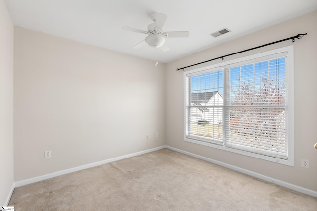 empty room with visible vents, baseboards, light colored carpet, and ceiling fan