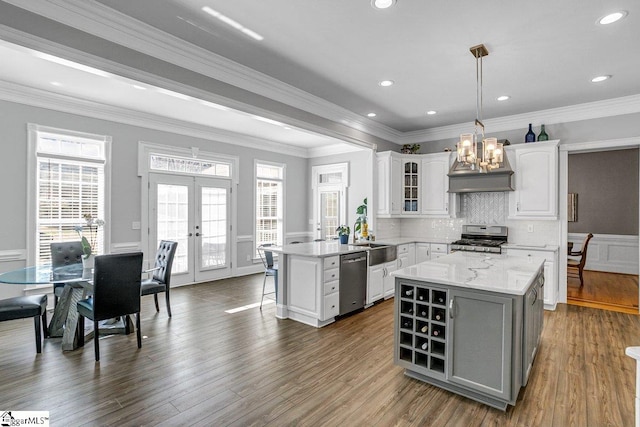 kitchen with stainless steel appliances, french doors, white cabinetry, a kitchen breakfast bar, and a center island