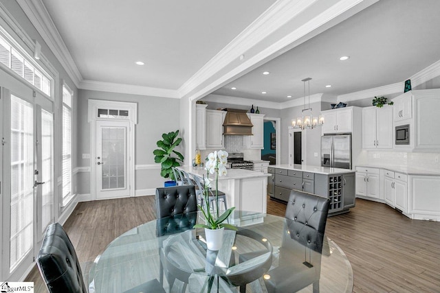 dining room featuring dark wood finished floors, recessed lighting, crown molding, and an inviting chandelier