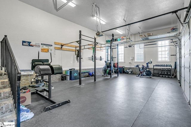 gym with a textured ceiling and a garage