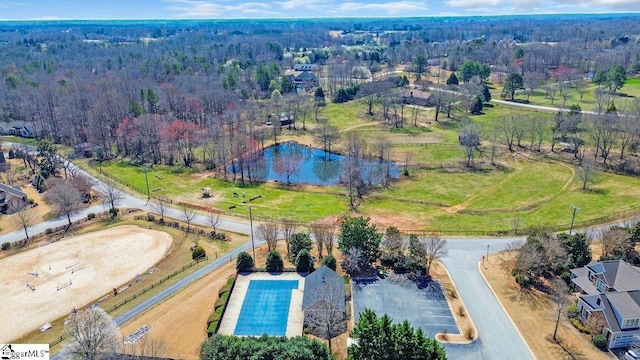 drone / aerial view featuring a water view and a wooded view