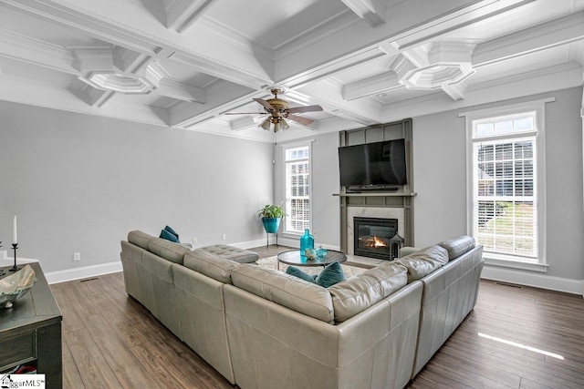 living area with a glass covered fireplace, coffered ceiling, baseboards, and wood-type flooring