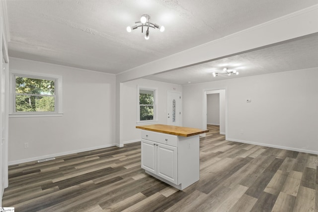 kitchen featuring dark wood-style floors, a healthy amount of sunlight, white cabinets, and butcher block counters