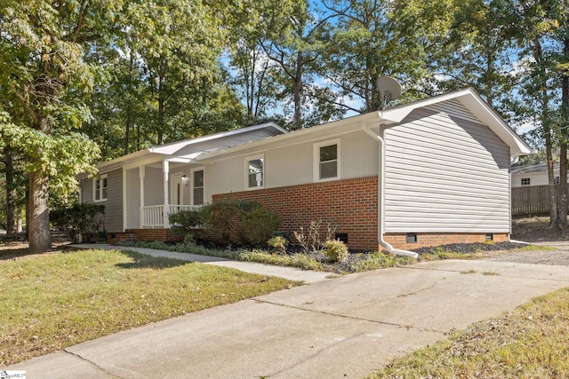 view of front facade featuring a front lawn, a porch, brick siding, and crawl space