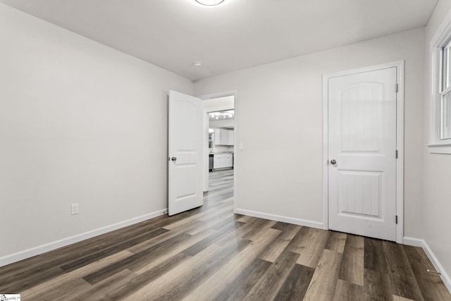 unfurnished bedroom featuring baseboards and wood finished floors