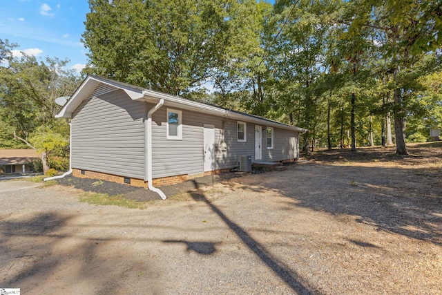 view of front of house featuring crawl space, cooling unit, and dirt driveway