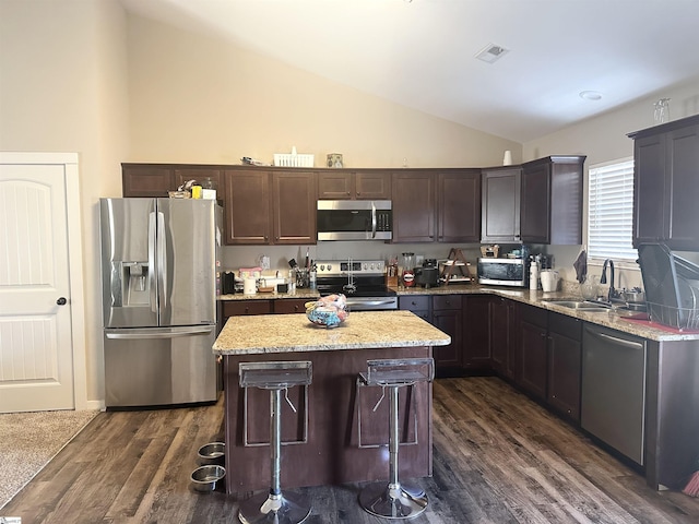 kitchen with visible vents, a kitchen island, dark wood finished floors, a sink, and appliances with stainless steel finishes