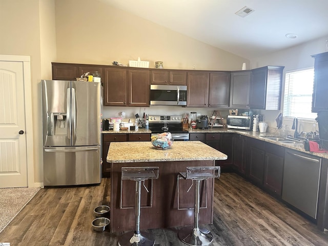 kitchen featuring visible vents, a sink, a kitchen island, dark wood finished floors, and appliances with stainless steel finishes