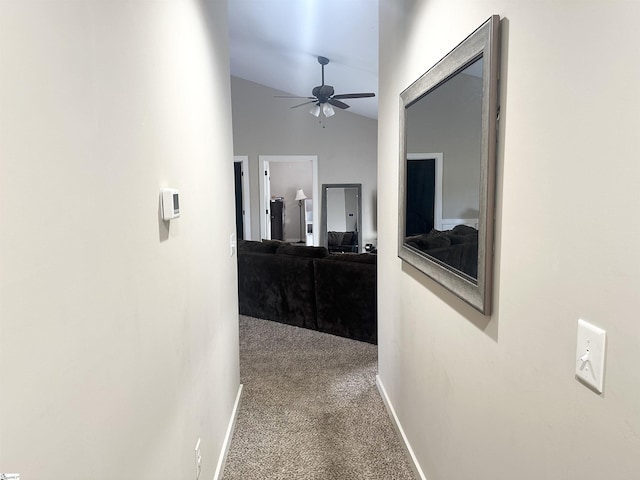 hallway with baseboards, carpet floors, and lofted ceiling