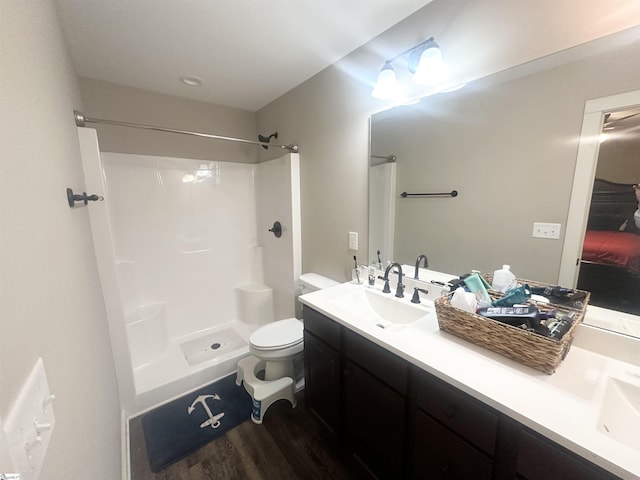 full bathroom featuring toilet, walk in shower, wood finished floors, and vanity