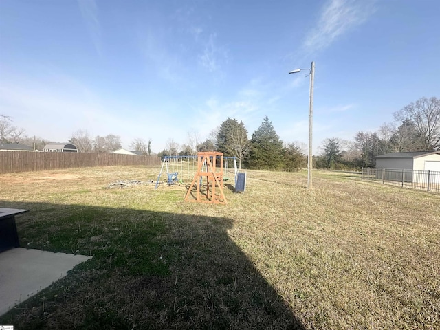 view of jungle gym with a lawn and fence