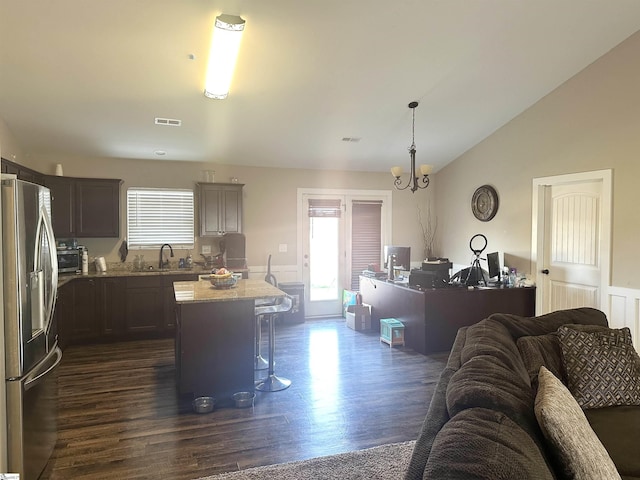 kitchen with a sink, plenty of natural light, open floor plan, and stainless steel refrigerator with ice dispenser