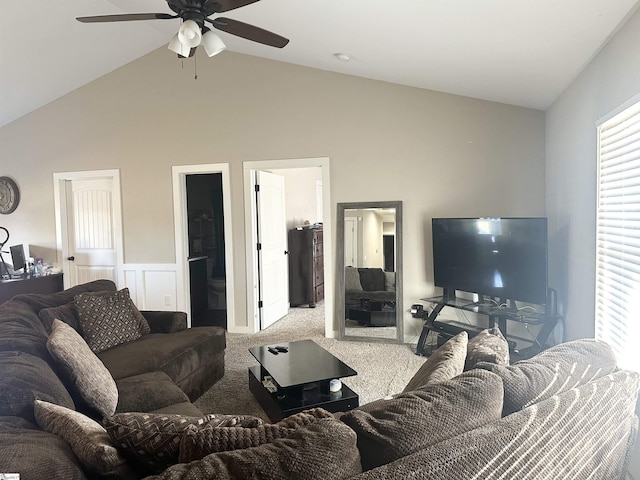 carpeted living area featuring a wainscoted wall, lofted ceiling, and a ceiling fan