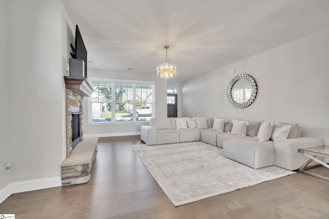 living room with baseboards, wood finished floors, and a fireplace