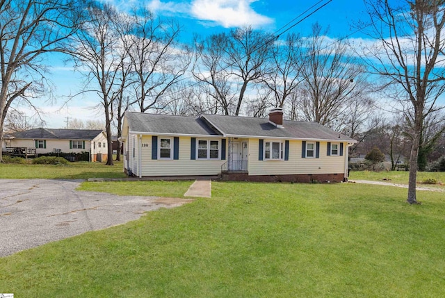 ranch-style home featuring a front yard, a chimney, and crawl space