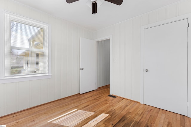 unfurnished bedroom with visible vents, crown molding, ceiling fan, and wood-type flooring