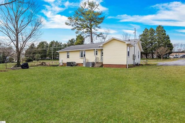 rear view of property with a yard and central AC unit