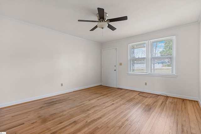 empty room featuring ceiling fan, light wood-type flooring, baseboards, and ornamental molding