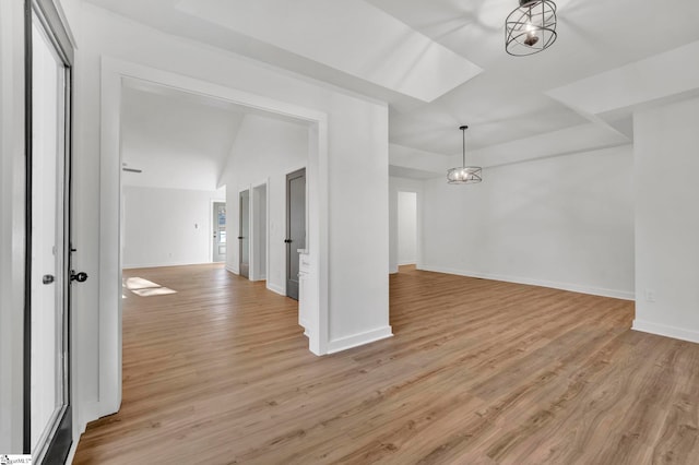 interior space with baseboards, lofted ceiling, and light wood-style floors