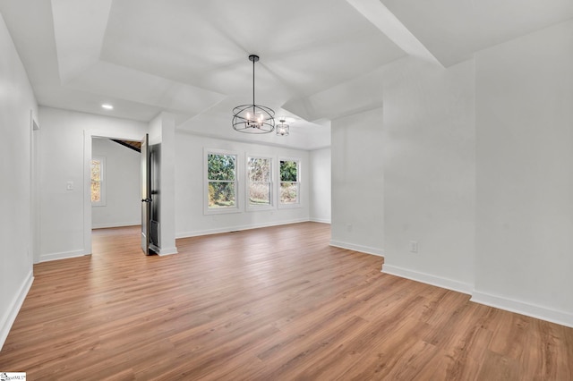 empty room with an inviting chandelier, recessed lighting, baseboards, and light wood finished floors