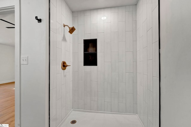 bathroom featuring a tile shower and wood finished floors