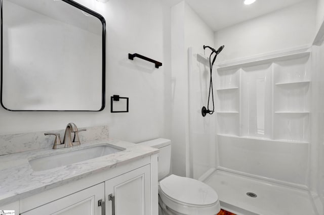 full bath with a stall shower, toilet, and vanity