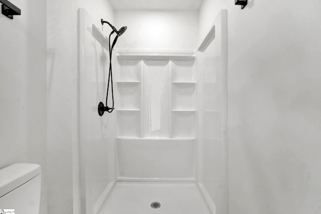 bathroom with toilet and a stall shower