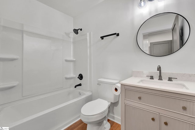 bathroom with vanity, wood finished floors, baseboards,  shower combination, and toilet