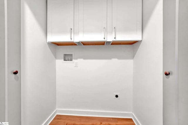 clothes washing area featuring washer hookup, wood finished floors, cabinet space, baseboards, and hookup for an electric dryer