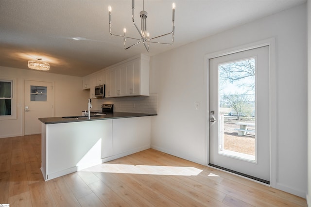 kitchen featuring dark countertops, plenty of natural light, a peninsula, and stainless steel appliances