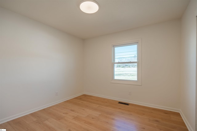 empty room with visible vents, baseboards, and light wood-type flooring