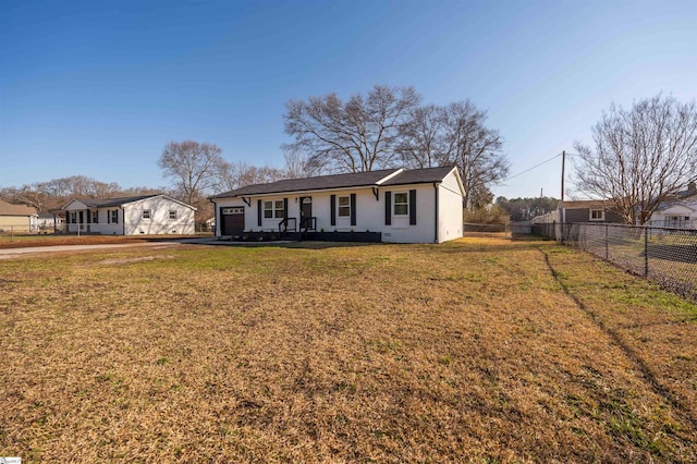 view of front of property with a front yard, an attached garage, and fence