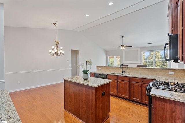 kitchen with tasteful backsplash, light wood-style flooring, black appliances, and a sink