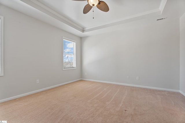 unfurnished room featuring baseboards, a raised ceiling, light colored carpet, and visible vents