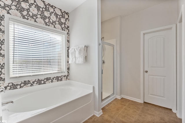 bathroom with tile patterned flooring, a garden tub, baseboards, and a stall shower