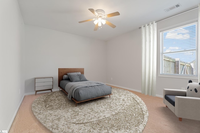 carpeted bedroom featuring visible vents, baseboards, and ceiling fan