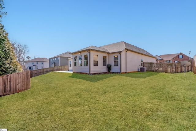 back of property featuring a fenced backyard, central AC unit, and a yard