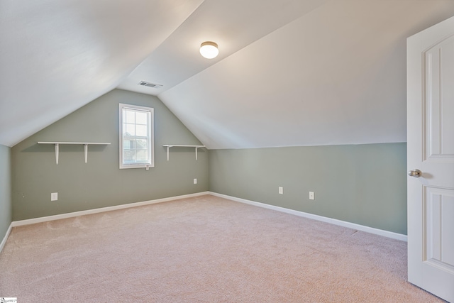 additional living space with visible vents, baseboards, carpet, and lofted ceiling