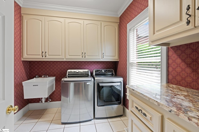 laundry area featuring independent washer and dryer, a sink, cabinet space, crown molding, and wallpapered walls