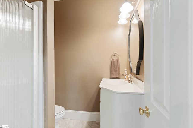 bathroom with vanity, toilet, baseboards, and tile patterned flooring