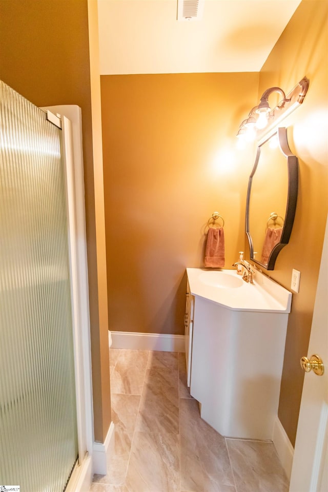 bathroom featuring visible vents, baseboards, tile patterned floors, an enclosed shower, and vanity