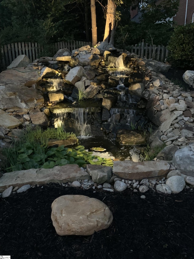 details featuring a small pond and fence