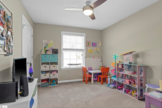 rec room featuring ceiling fan, carpet, baseboards, and a textured ceiling