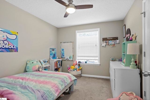 bedroom with a ceiling fan, light colored carpet, baseboards, and a textured ceiling