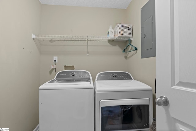 washroom with electric panel, laundry area, a textured ceiling, and washing machine and clothes dryer