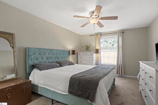 carpeted bedroom with a ceiling fan, baseboards, and a textured ceiling