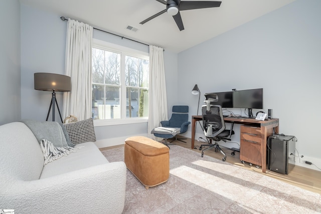 home office featuring baseboards, wood finished floors, visible vents, and ceiling fan