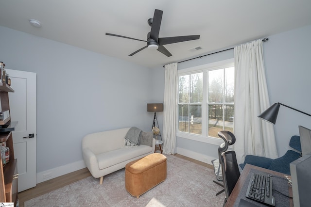 office area with visible vents, baseboards, wood finished floors, and a ceiling fan