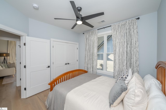 bedroom featuring visible vents, light wood-style floors, a closet, and ceiling fan