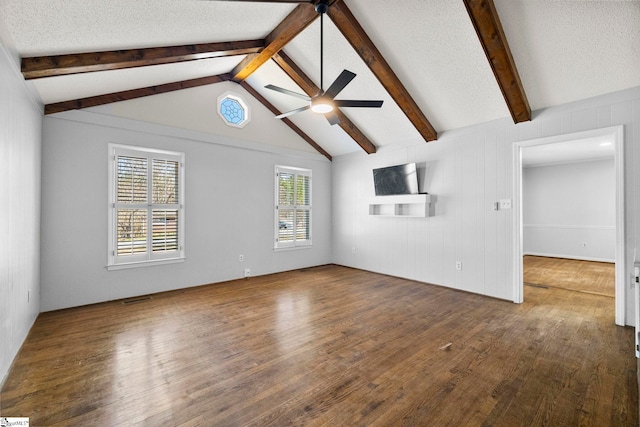 unfurnished living room with vaulted ceiling with beams, a textured ceiling, ceiling fan, and hardwood / wood-style flooring